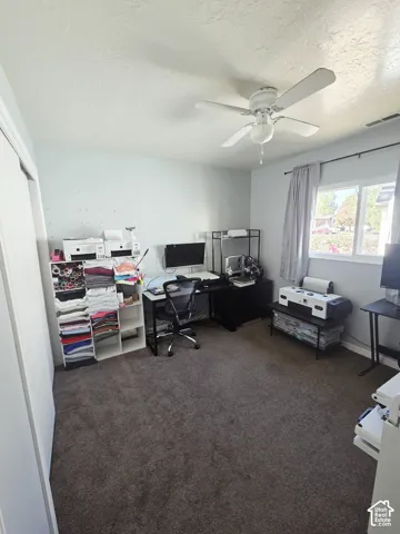 Wall-to-wall carpeting with a ceiling fan overhead