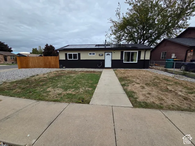 Siding exterior with a clean architectural design, modern solar panels, and a concrete pathway leading to the entry