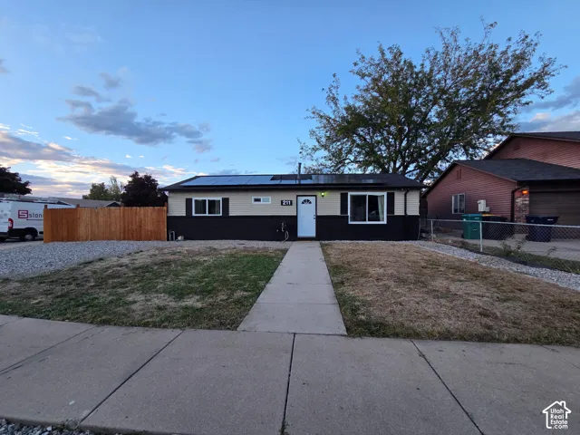 Contemporary single-story residence featuring a clean facade with black and white exterior trim, central entry door, and dual front-facing windows