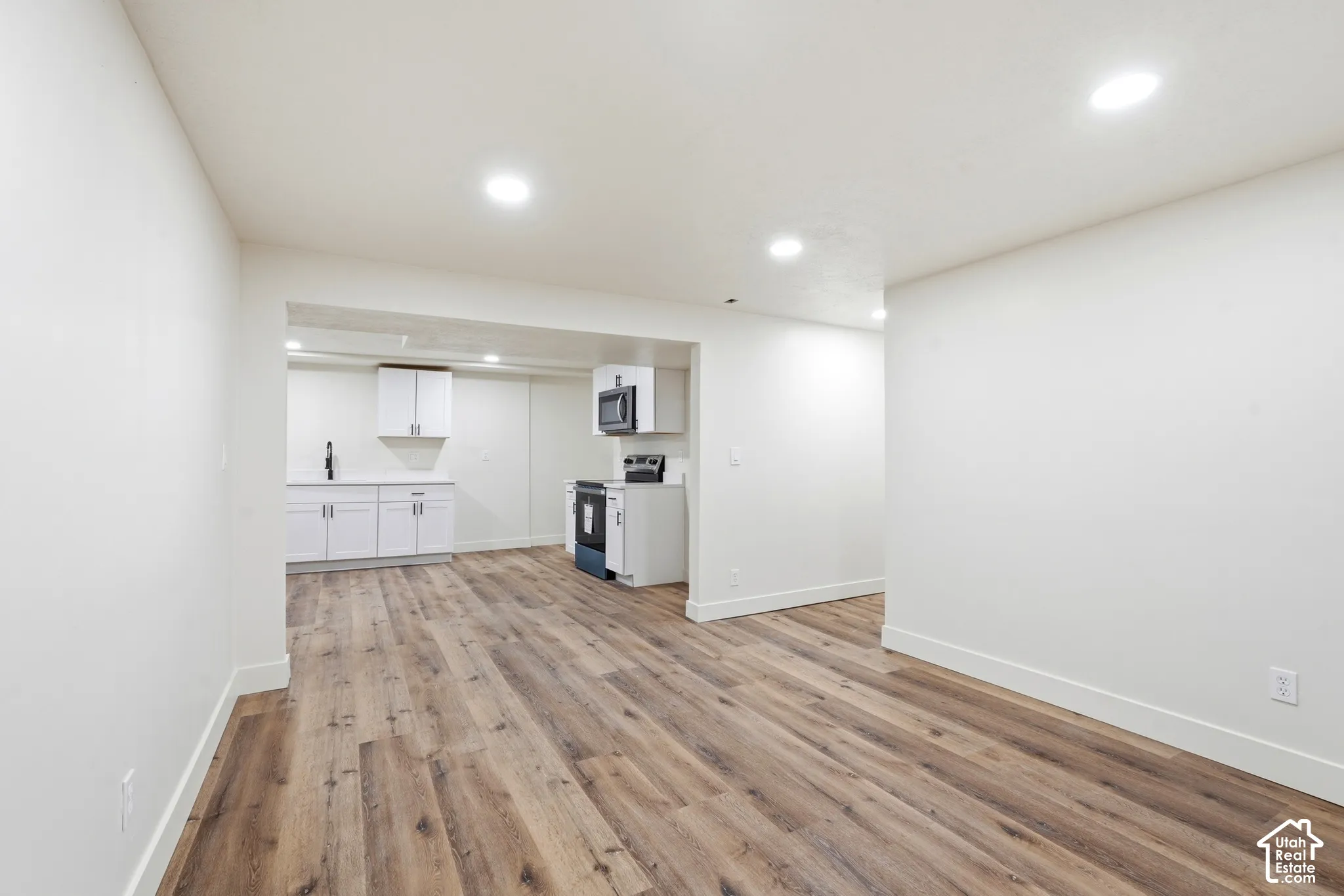Recessed lighting illuminates wood-finish flooring