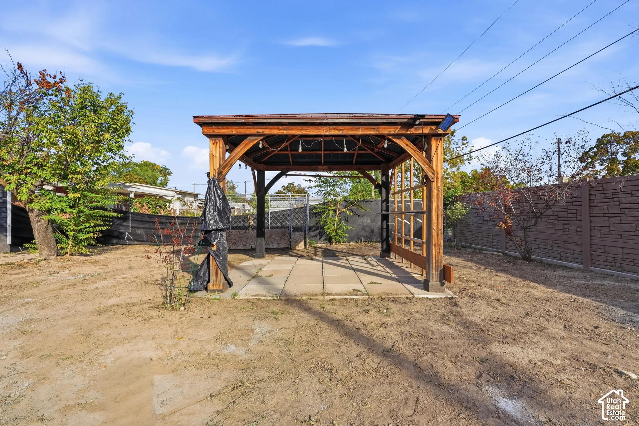 Wood-frame pergola with string lighting over a paver patio