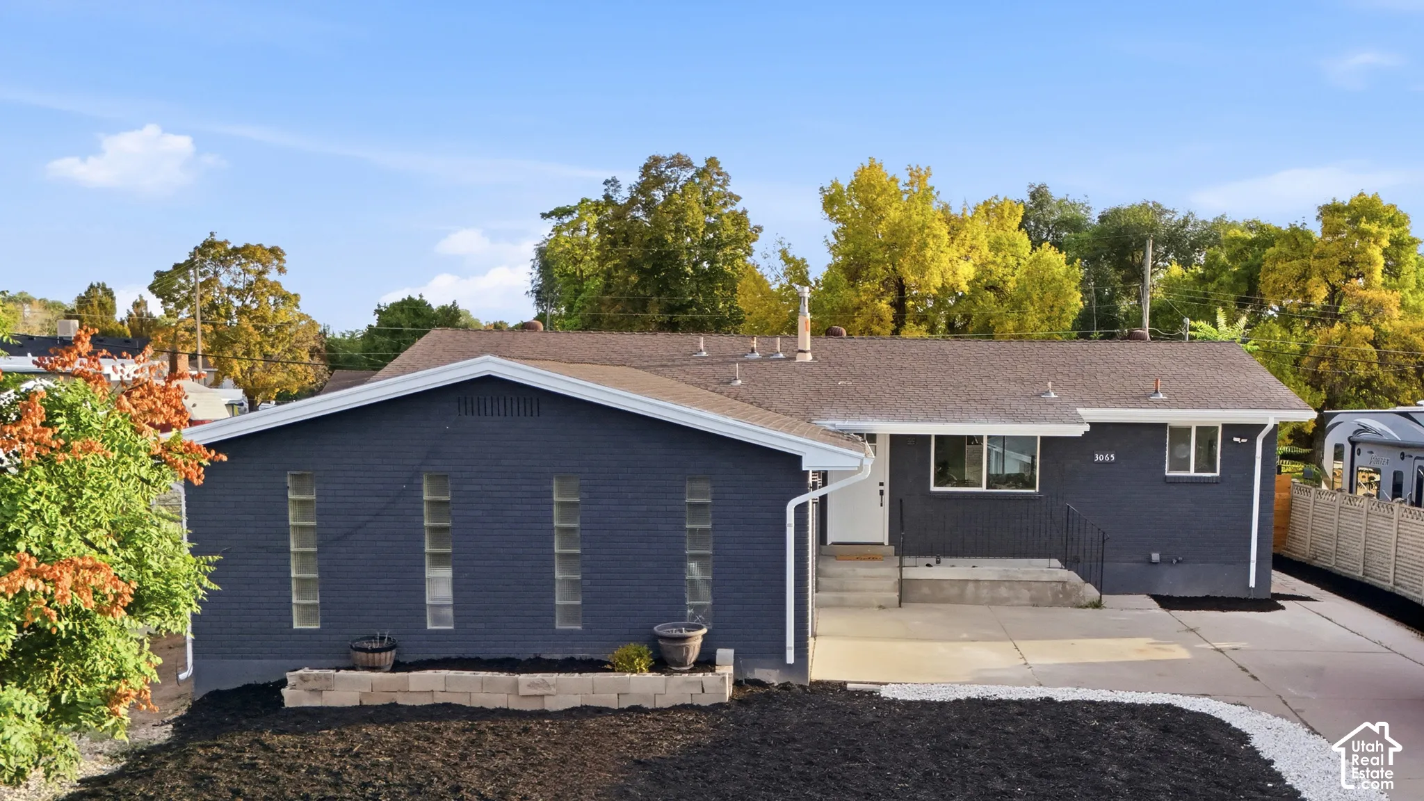 Contemporary exterior with dark-painted brickwork, white trim, and a gabled roofline