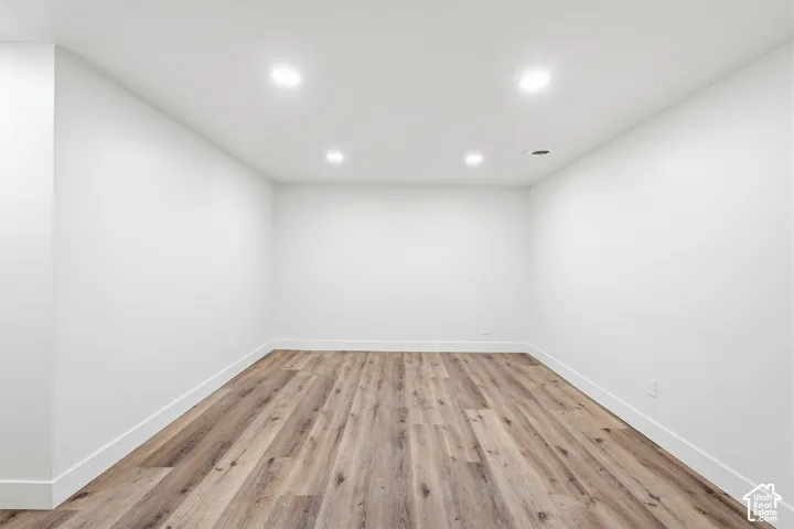Recessed lighting, wood-finish flooring, and crisp white walls