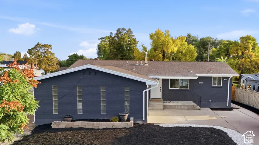 Contemporary exterior with dark-painted brickwork, white trim, and a gabled roofline