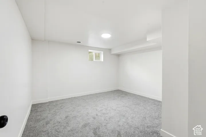 Neutral wall finishes, recessed lighting, and grey carpet flooring