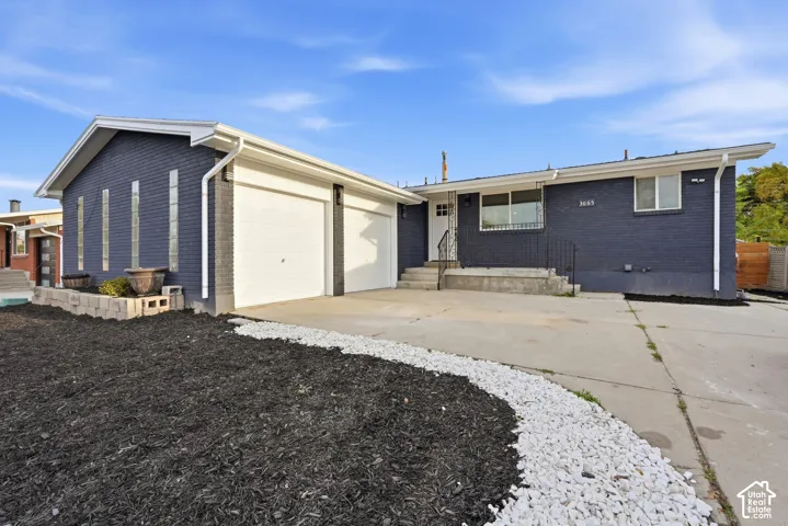 Exterior featuring dark painted brick, white trim, and a two-car garage
