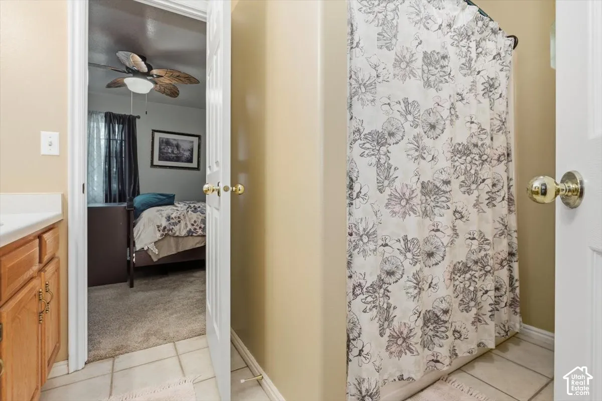 Bathroom with tile flooring and a light wood-finish vanity