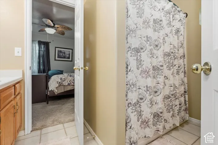 Bathroom with tile flooring and a light wood-finish vanity