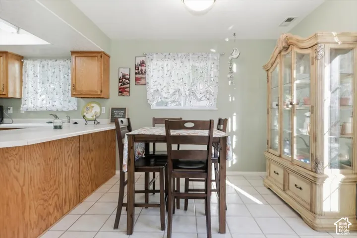 Kitchen features wood cabinetry, a white countertop, and a skylight