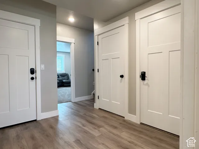 Wood-finish flooring with white trim and paneled doors