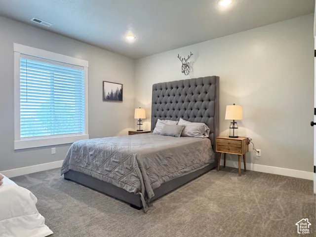 Recessed lighting and a single window with blinds and white trim