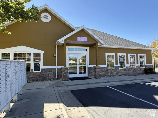 Stucco exterior with stone veneer accents, multi-pane windows, and a covered entry