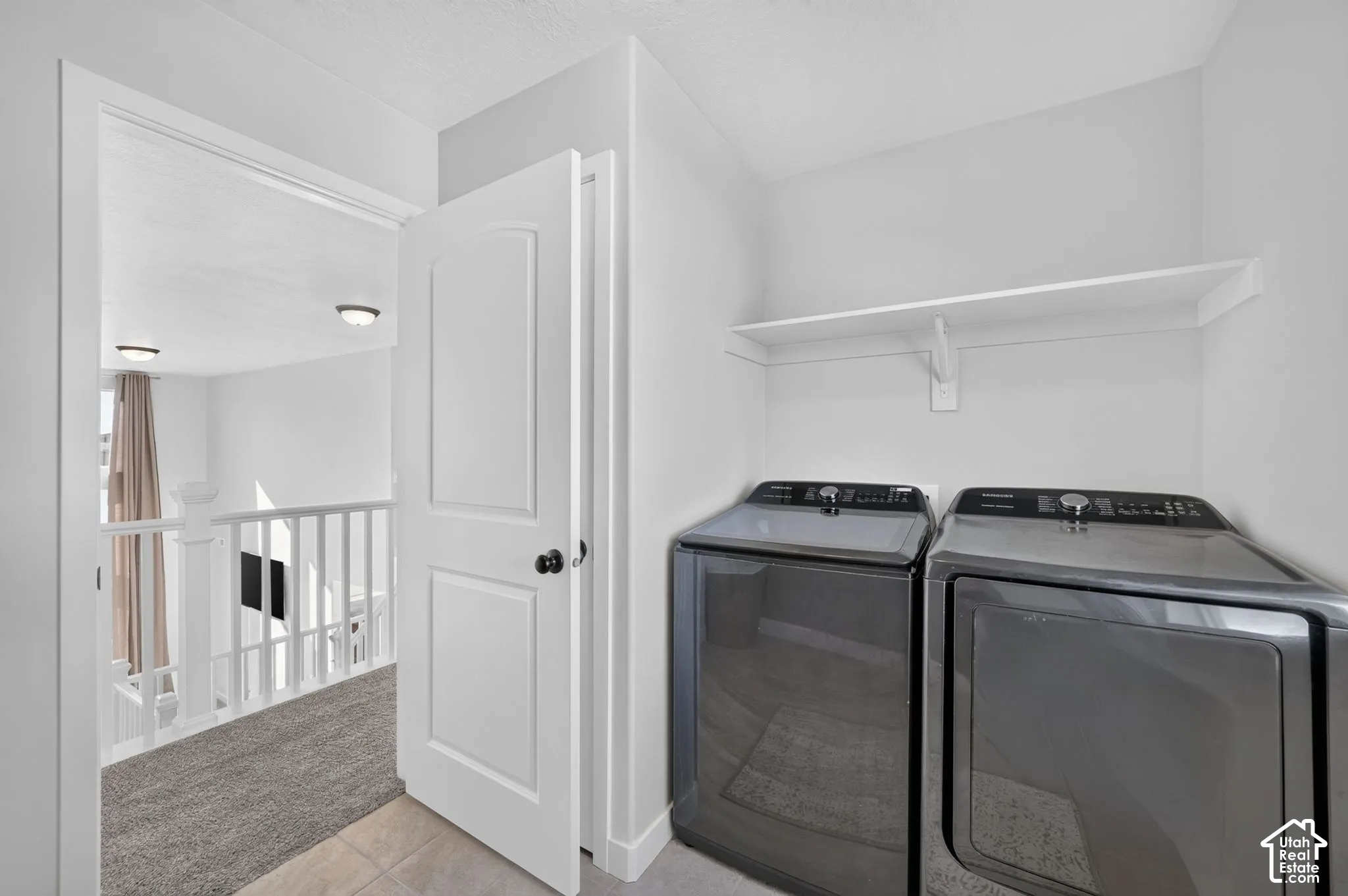 Dedicated laundry area featuring a wall-mounted shelf and tile flooring