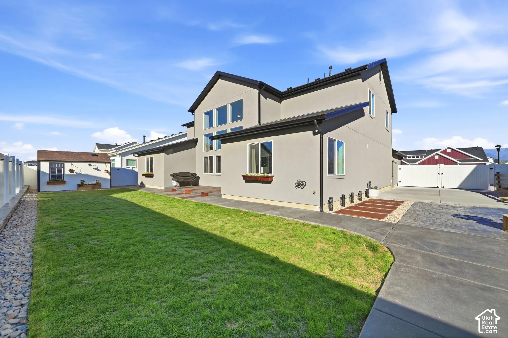 Exterior with a stucco finish, multiple windows, and a paved patio area