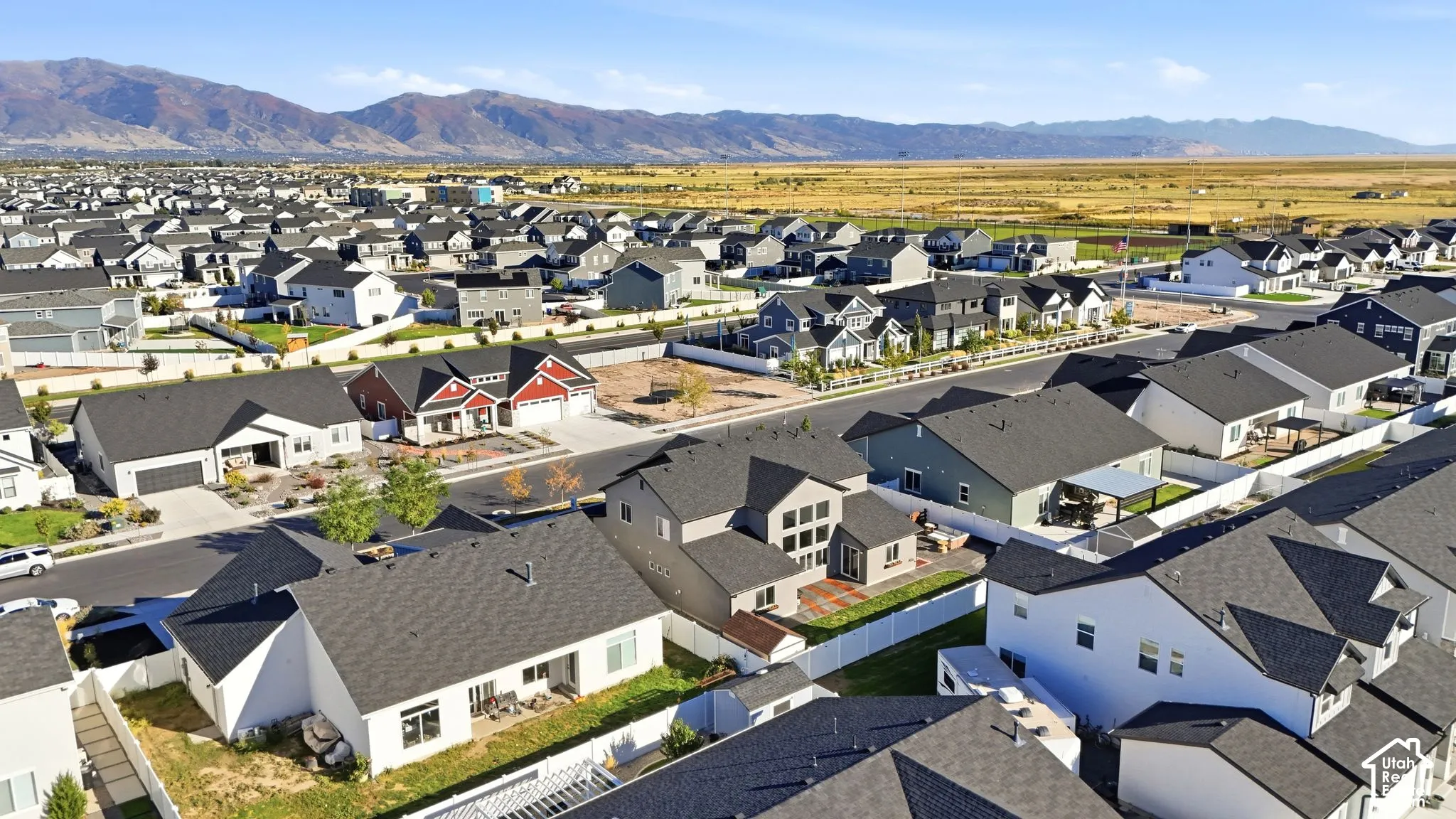 Expansive residential area with a clear mountain backdrop and open field