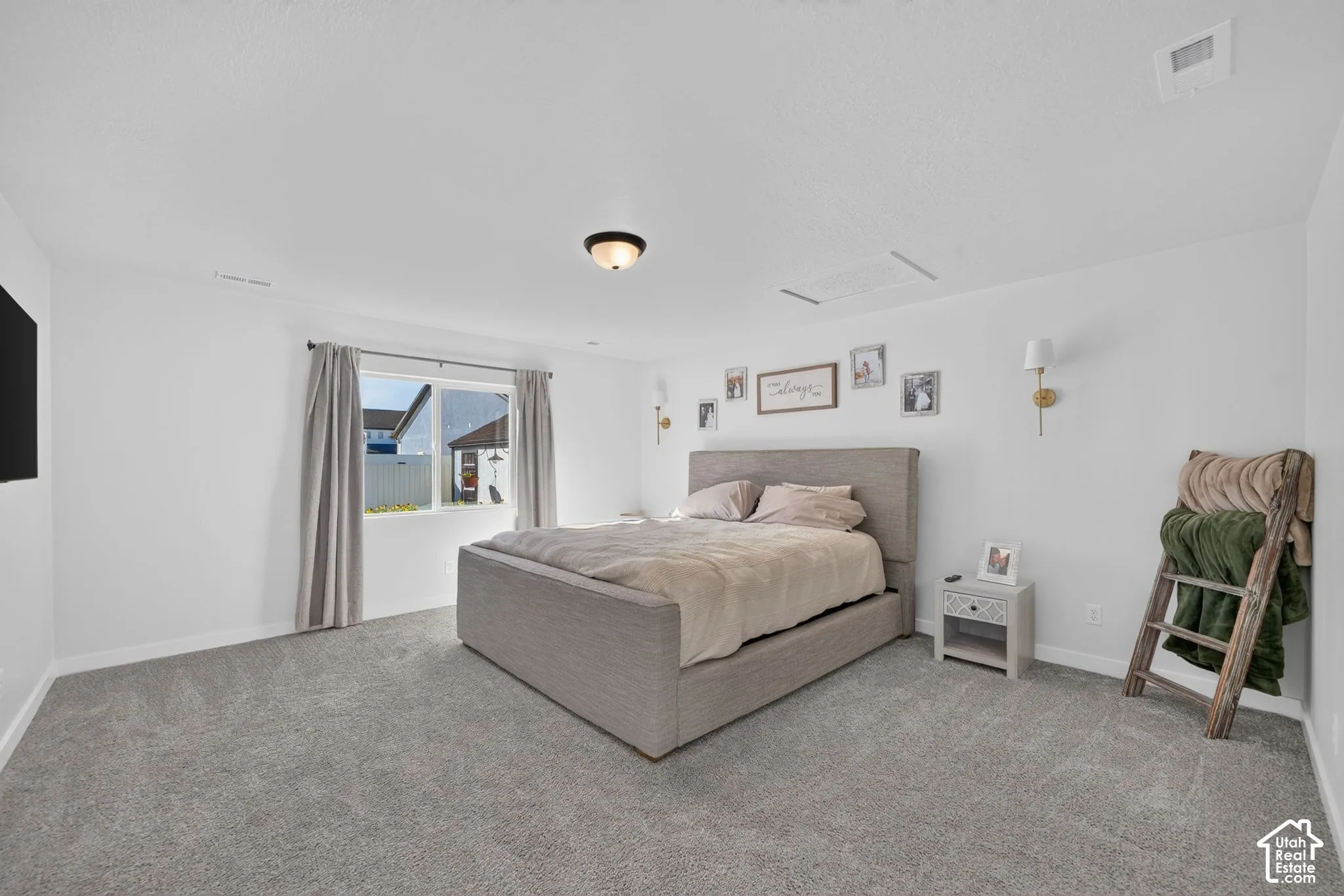 Spacious room with gray carpet flooring, white walls, and a large window