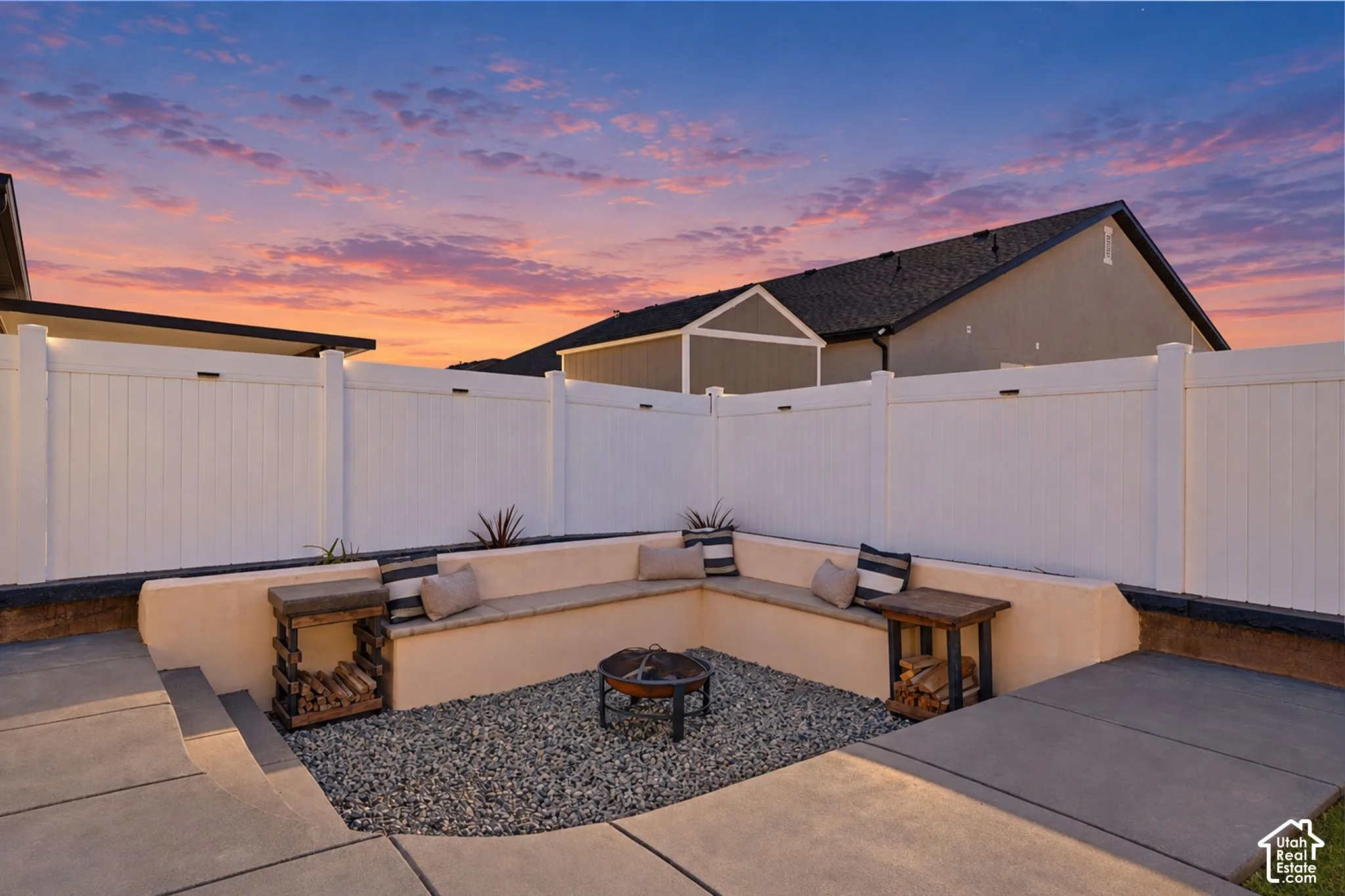 Recessed patio featuring built-in seating, gravel ground cover, and a central fire pit