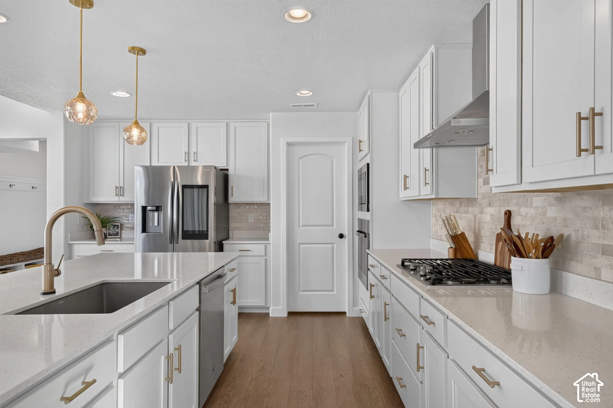 Modern kitchen featuring white cabinetry, light-toned countertops, and stainless steel appliances