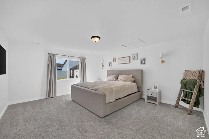 Spacious room with gray carpet flooring, white walls, and a large window