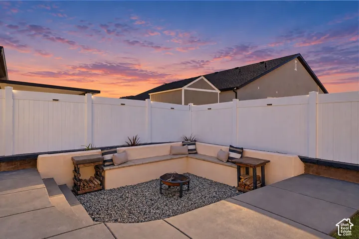 Recessed patio featuring built-in seating, gravel ground cover, and a central fire pit