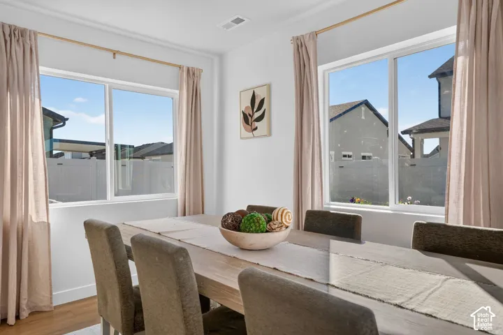 Formal dining area featuring two large windows, white walls, and wood-finish flooring