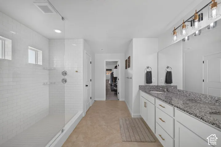 Walk-in shower with subway tile surround, clear glass enclosure, and recessed lighting