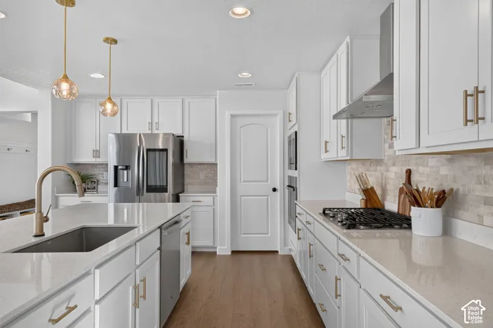 Modern kitchen featuring white cabinetry, light-toned countertops, and stainless steel appliances