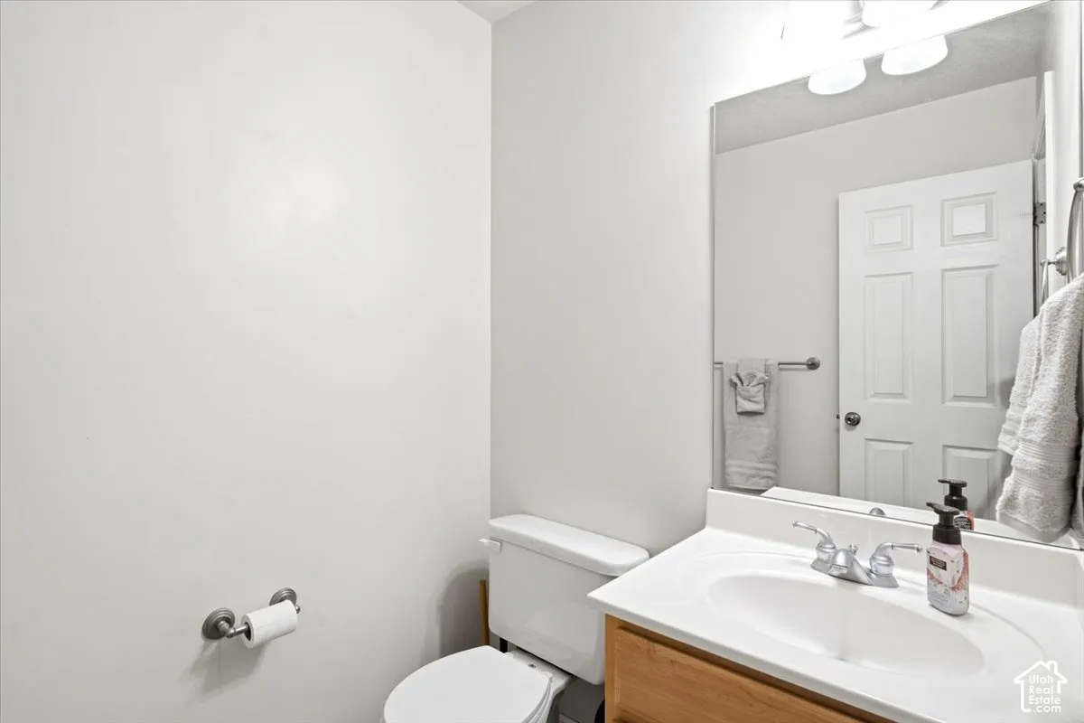 White panel door, wood-finish vanity with an integrated sink, polished chrome faucet, and a wall-mounted mirror