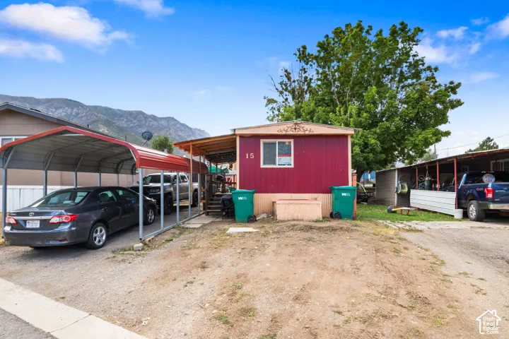 Red-sided residence with covered front entry and a multi-vehicle carport