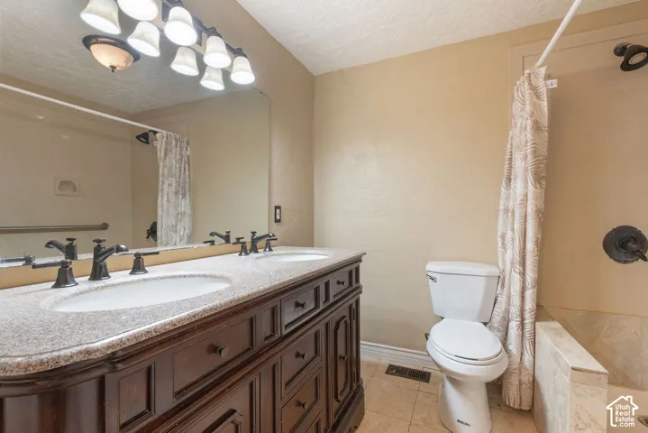 Dual vanity with dark wood-finish cabinetry, light speckled countertop, and undermount sinks