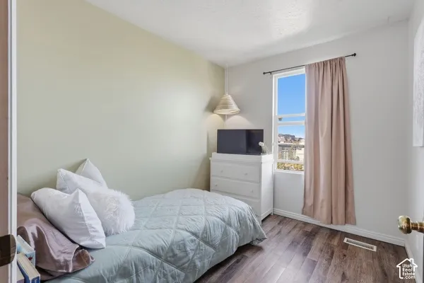 Wood-finish flooring, single window, white trim, and light-colored walls