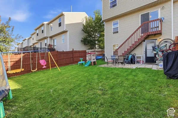 Rear exterior featuring a ground-level patio, private fenced yard, and a deck with stairs
