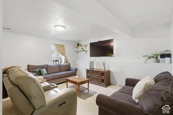 Recessed ceiling lights illuminate this living space with a wall-mounted entertainment center and a built-in shelf