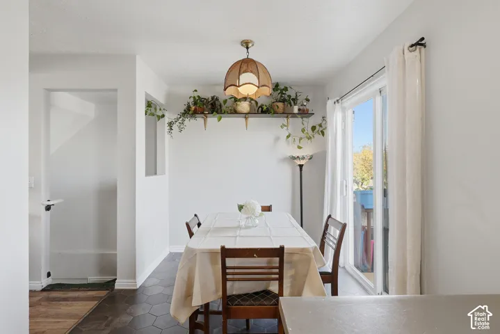 Dining area with hexagonal floor tiles, a sliding glass door, and a decorative wall shelf