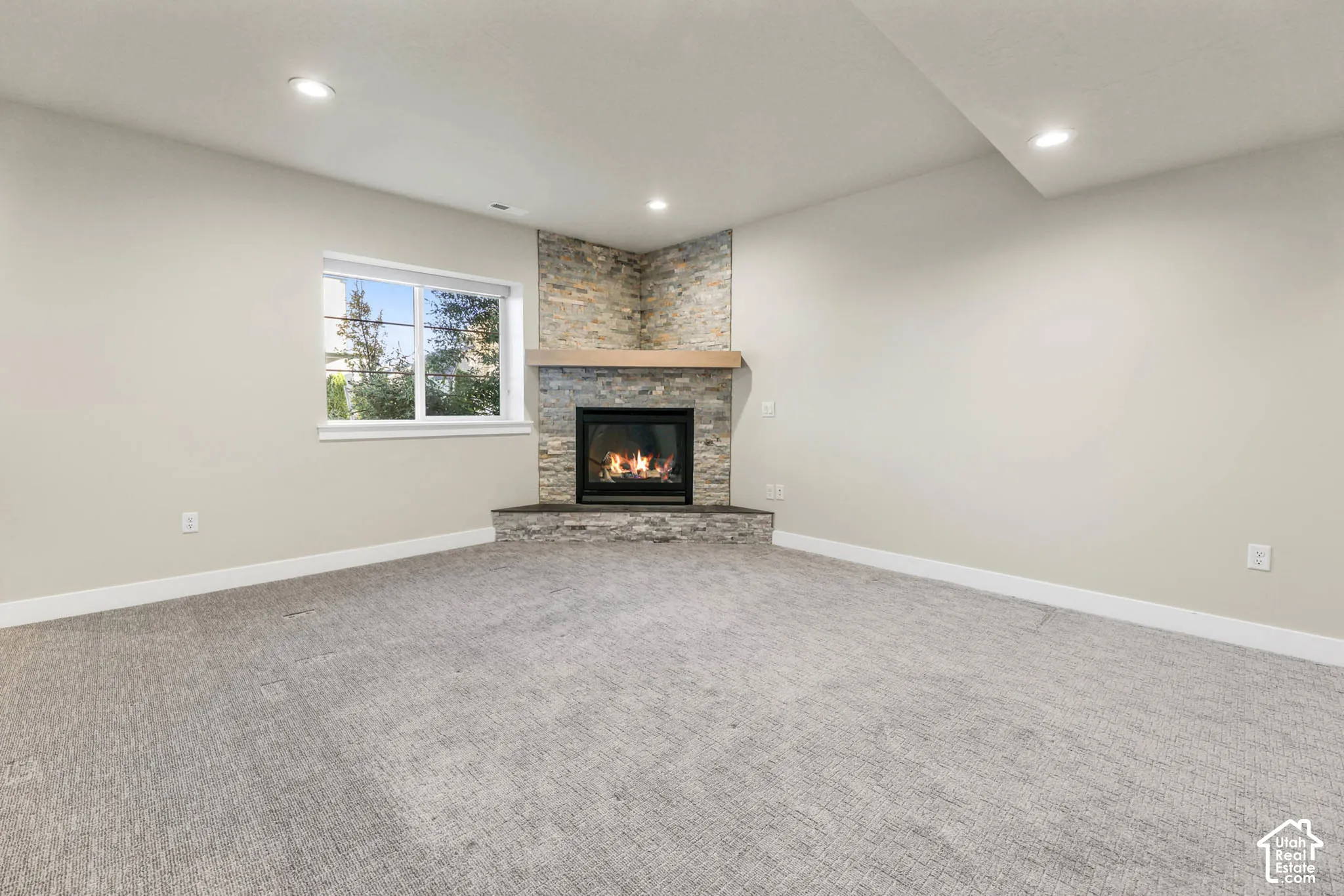 Corner fireplace with stone surround and wood mantel