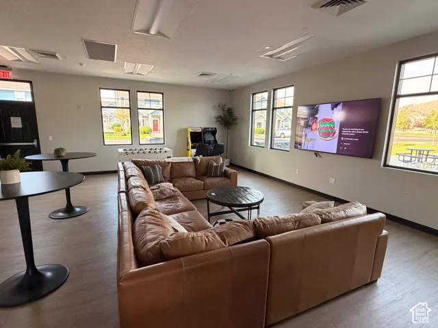 Spacious gathering area featuring wood-finish flooring, multiple windows, and recessed lighting