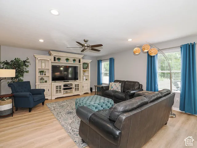 Open-concept family room with custom wood blinds and hunter ceiling fan.