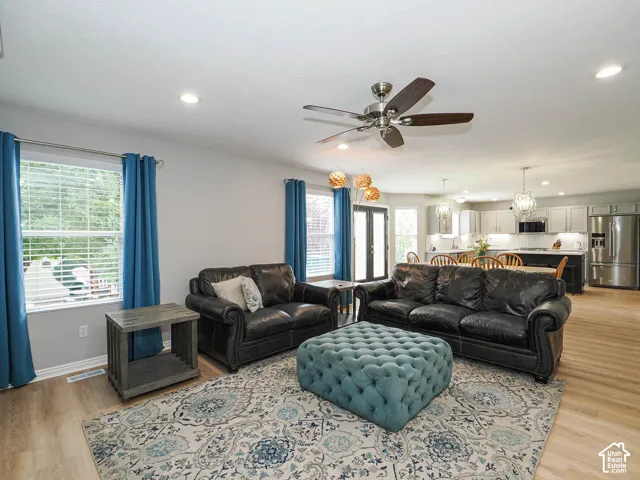 Open-concept family room featuring new lvp wood-finish flooring, recessed led lighting, and a ceiling fan.