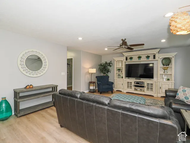Large family room featuring light wood-finish flooring, recessed lighting, and a ceiling fan.