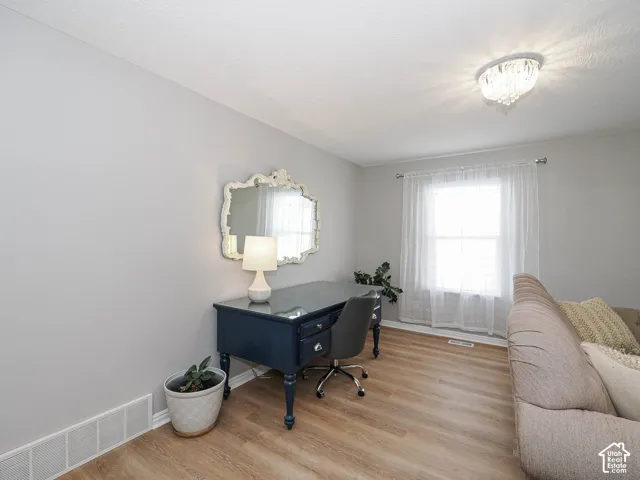 Bright living area featuring new lvp wood-finish flooring, custom wood blinds, new light gray wall paint, and white trim.