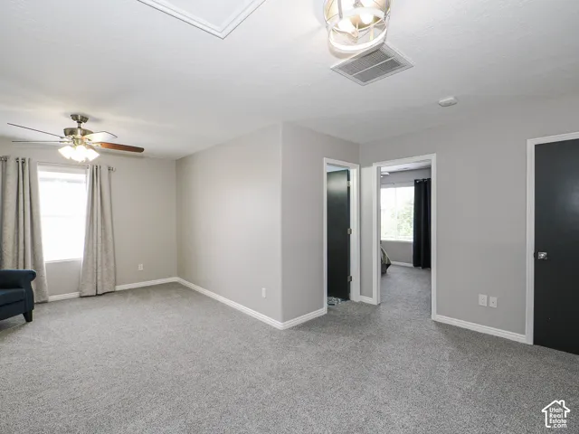Open carpeted loft featuring light gray walls and white trim.