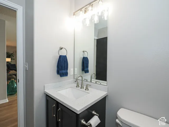 Bathroom featuring a single-sink vanity with new white Corian countertop, dark wood-finish cabinetry, and brushed nickel hardware with new matching light fixture.