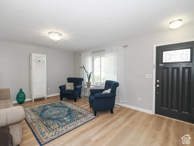Bright living area featuring wood-finish flooring, light gray wall paint, and white trim
