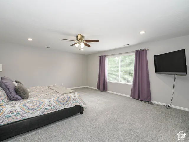 Master bedroom featuring newly painted light gray walls and new plush gray carpeting.