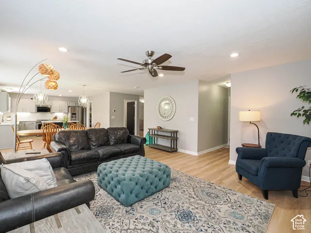 Open-concept living area/family room featuring wood-finish flooring, recessed lighting, and a ceiling fan.