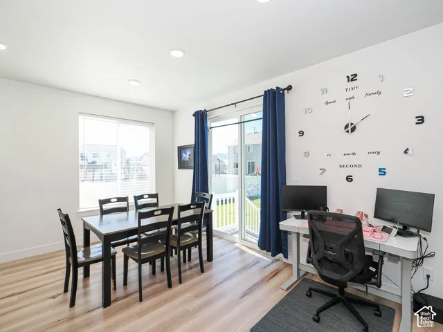 Recessed ceiling lighting, wood-finish flooring, and a sliding glass door with balcony access