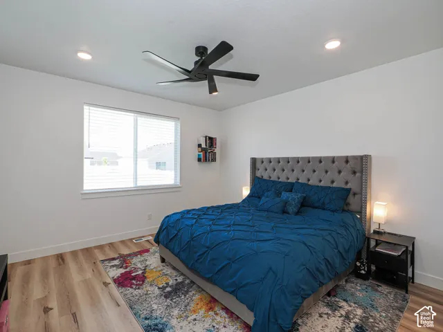 Recessed ceiling lighting, wood-finish flooring, and a window with blinds