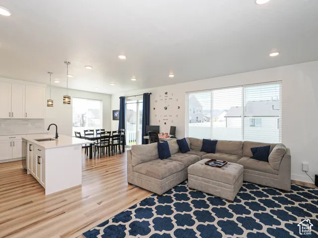 Open-concept living space featuring wood-finish flooring, recessed lighting, and a kitchen island with seating