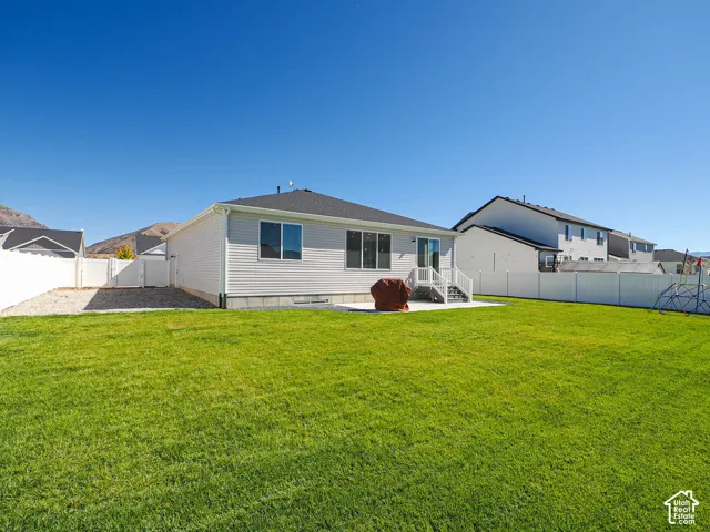 Expansive green lawn with a white privacy fence