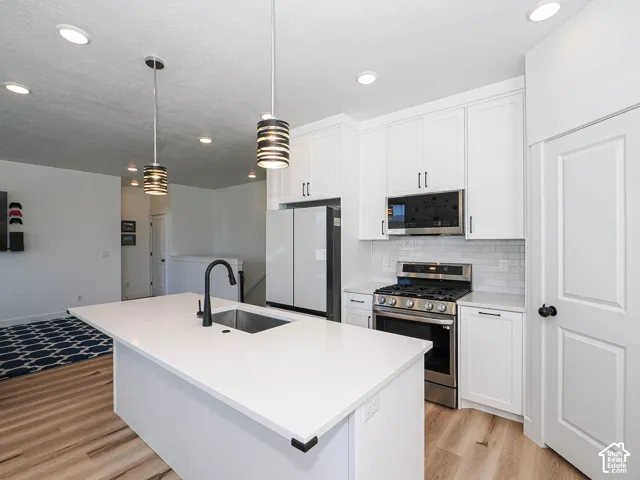 Modern kitchen featuring a large center island with white cabinetry, stainless steel gas range, and integrated microwave